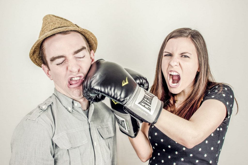 Woman with boxing gloves punching a man