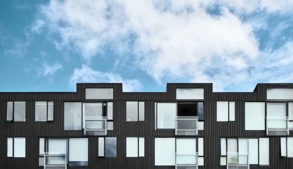 black apartments under a blue sky