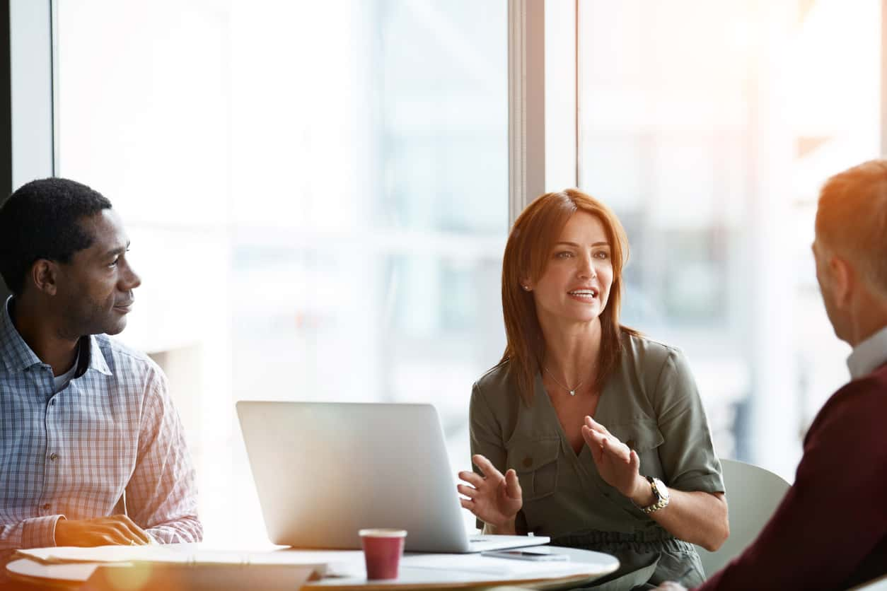 Shot of three professional business people meeting in their office